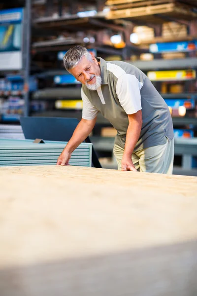 Homem comprando madeira de construção em uma loja de bricolage — Fotografia de Stock