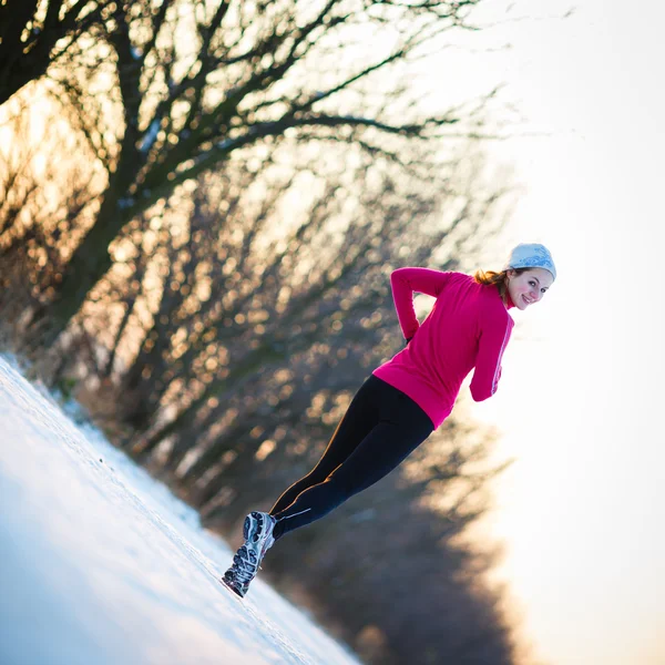 Νεαρή γυναίκα που τρέχει σε εξωτερικούς χώρους, μια κρύα χειμερινή ημέρα — Φωτογραφία Αρχείου
