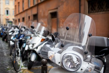 Row of motorbikes and scooters parked in one of the ancient stre