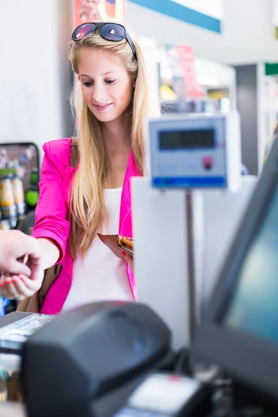 Hermosa joven pagando por sus compras — Foto de Stock