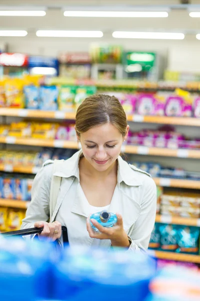 Beautiful young woman shopping in a grocery supermarket — Stock Photo, Image