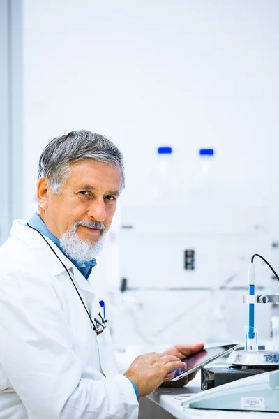 Médico senior usando su tableta en el trabajo —  Fotos de Stock