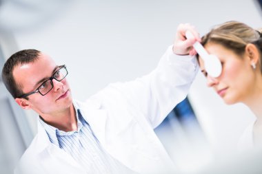 Optometri kavramı - genç ve güzel kadın gözleri muayene olması