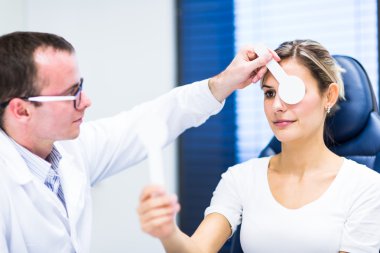 Optometri kavramı - genç ve güzel kadın gözleri muayene olması