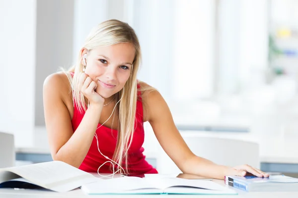 En la biblioteca - estudiante bastante femenina con libros que trabajan en una h — Foto de Stock