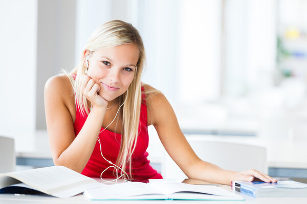 in the library - pretty female student with books working in a h