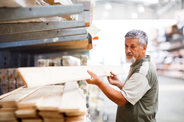 Homem sênior comprando madeira de construção em uma loja DIY — Fotografia de Stock