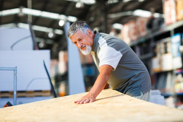 Senior man buying construction wood in a DIY store — Stock Photo, Image