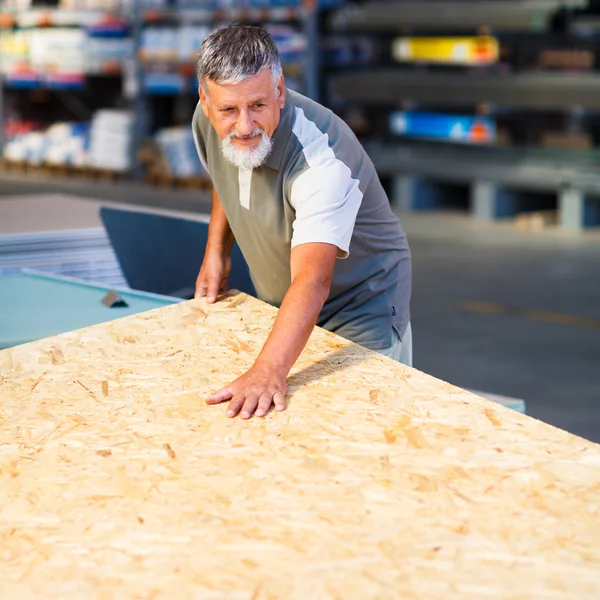 Senior man buying construction wood in a DIY store — Stock Photo, Image