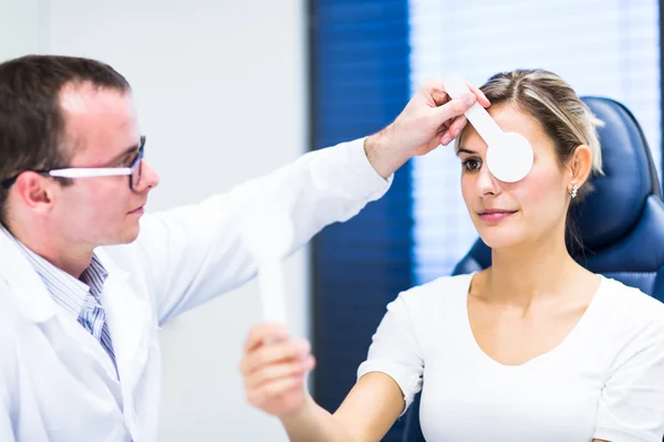 Concepto de optometría: mujer joven y bonita que examina sus ojos — Foto de Stock