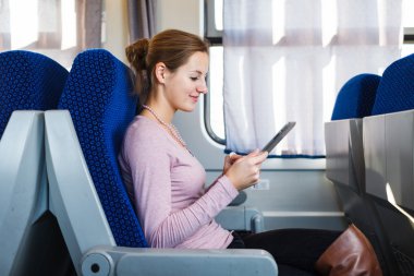 trenle seyahat ederken onun tablet bilgisayar kullanan genç kadın