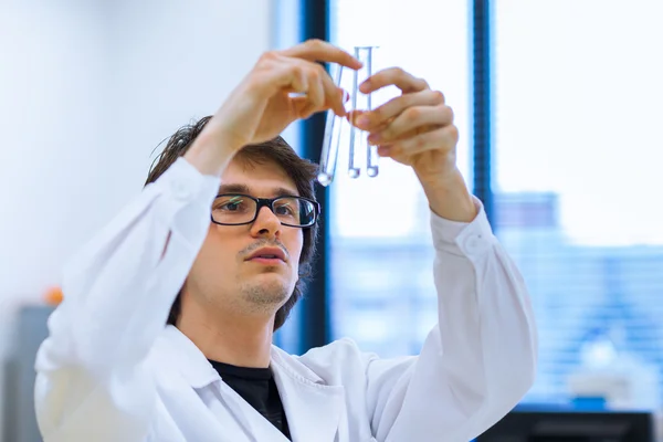 Joven investigador masculino que realiza investigación científica en un laboratorio — Foto de Stock