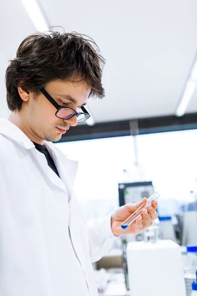 Молодой исследователь-мужчина проводит научные исследования в лаборатории — стоковое фото