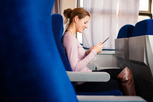 Jovem mulher usando seu computador tablet enquanto viaja de trem — Fotografia de Stock