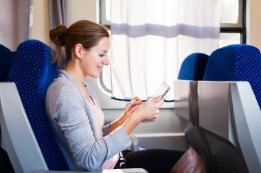 trenle seyahat ederken onun tablet bilgisayar kullanan genç kadın