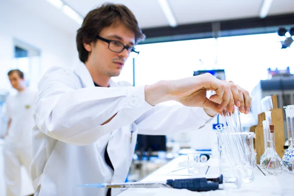 Jovem pesquisador do sexo masculino que realiza pesquisa científica em laboratório — Fotografia de Stock