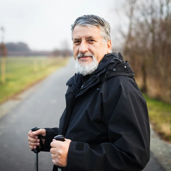 Старший мужчина нордическая ходьба, наслаждаясь на открытом воздухе — стоковое фото