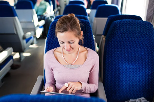 Jonge vrouw met behulp van haar tablet-pc terwijl het reizen met de trein — Stockfoto