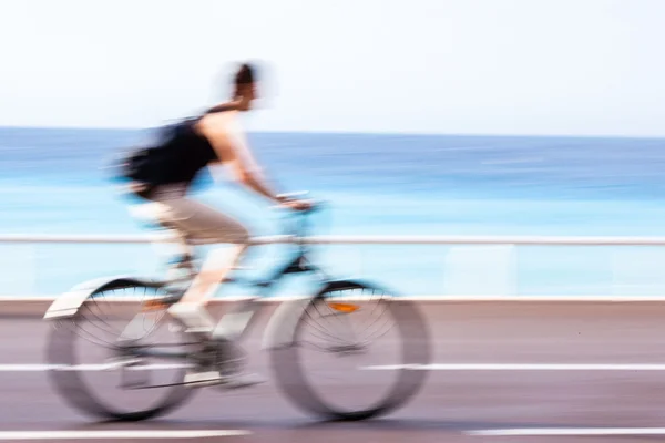 Great way to get around in a city -Motion blurred cyclist going — Stock Photo, Image