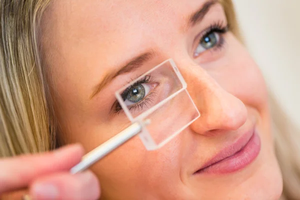 Optometrie koncept - krásná mladá žena mají oči zkoumal — Stock fotografie