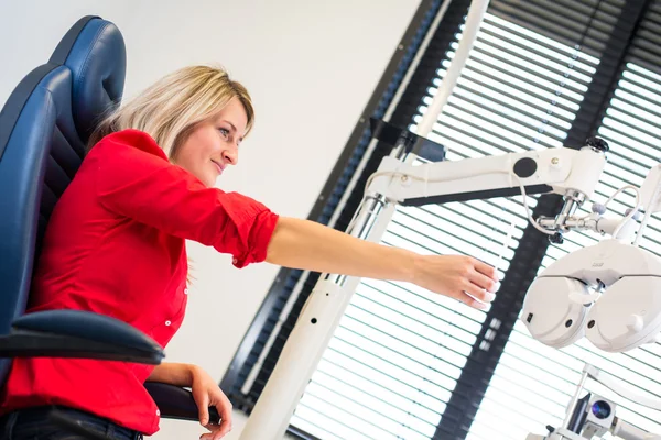 Optometrie concept - vrij jonge vrouw met haar ogen onderzocht — Stockfoto