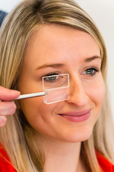 Concepto de optometría: mujer joven y bonita que examina sus ojos — Foto de Stock