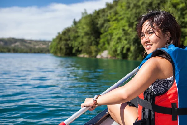 Hübsche, junge Frau auf einem Kanu auf einem See, paddelnd, — Stockfoto