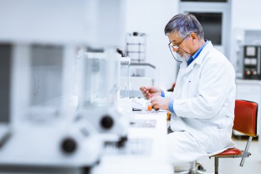 bir laboratuvarda bilimsel araştırmalar yürüten uzman erkek araştırmacı