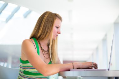dizüstü bilgisayarında çalışan güzel Bayan üniversite öğrencisi