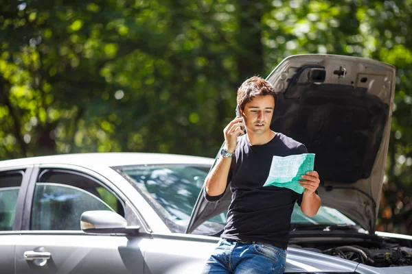 Bonito jovem pedindo ajuda com seu carro quebrado fazer — Fotografia de Stock