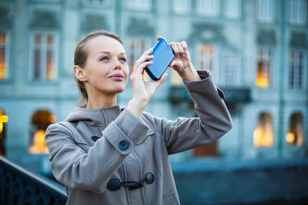 Elegancki, młoda kobieta, robienie zdjęć z jej aparat fotograficzny telefon komórkowy — Zdjęcie stockowe