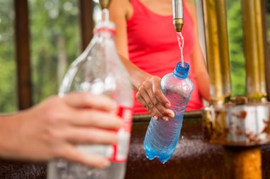 Woman fillig a plastic bottle clipart