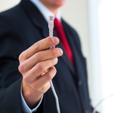 ethernet kablosu tutan işadamı