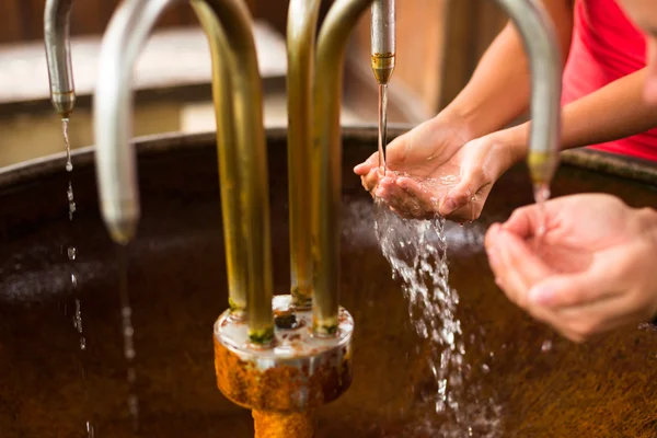 People filling up their hands with water — Stock Photo, Image
