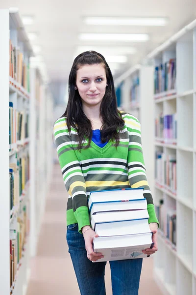 Vrouwelijke student op zoek naar boeken — Stockfoto