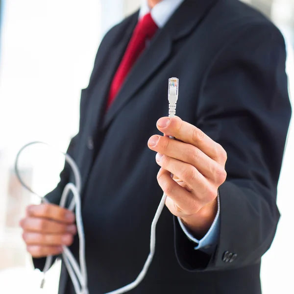 Uomo d'affari in possesso di un cavo ethernet — Foto Stock