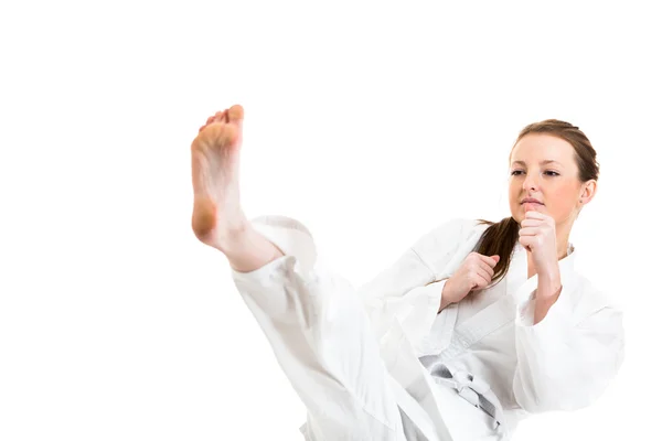 Woman makes a kick in karate kimono — Stock Photo, Image