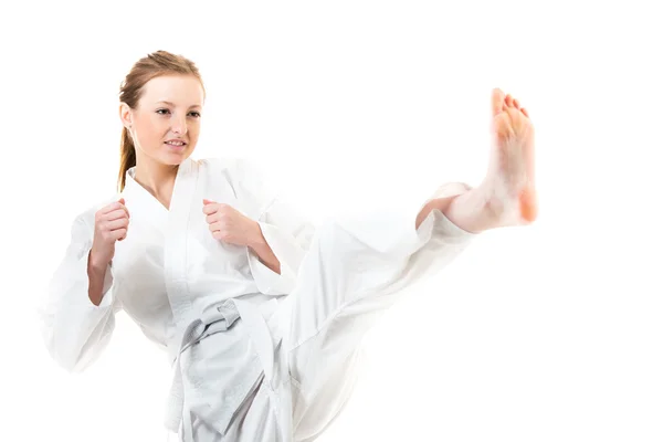 Frau macht einen Tritt im Karate-Kimono — Stockfoto