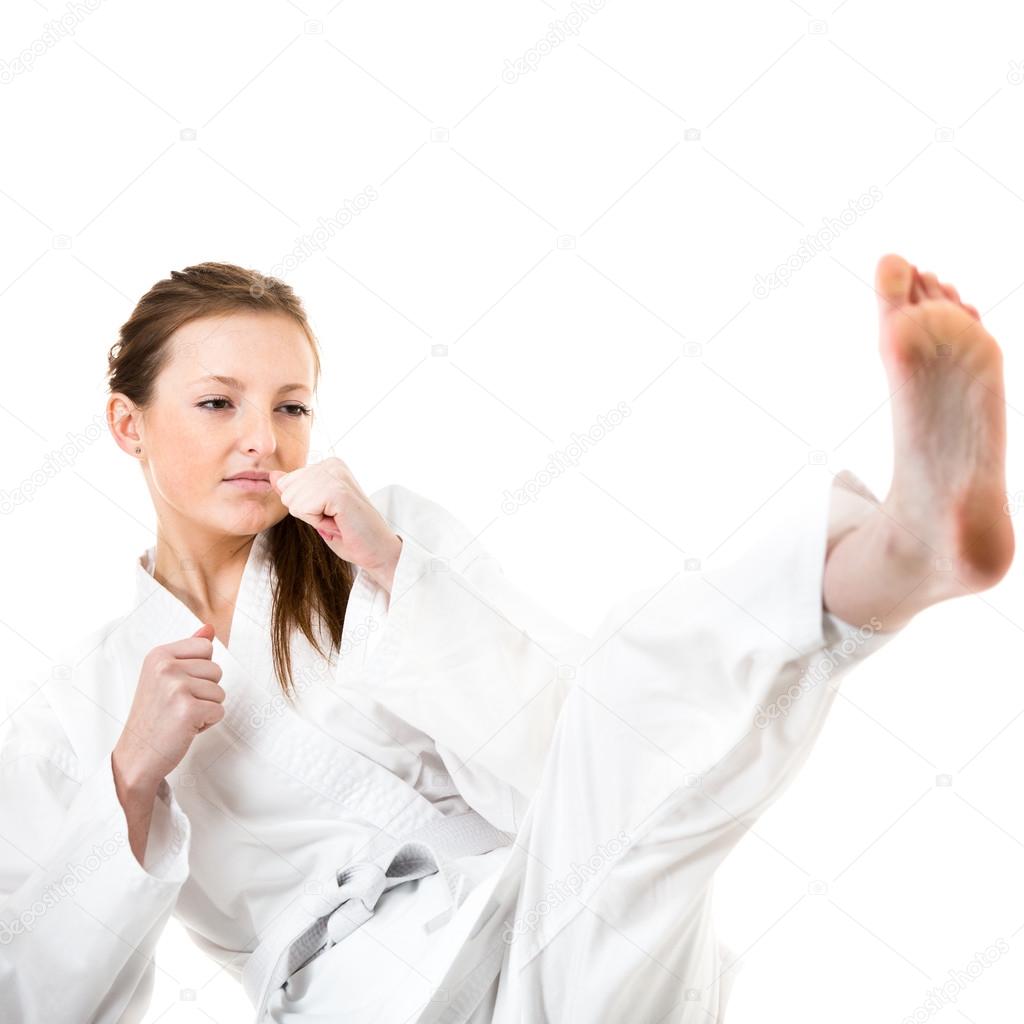 Woman makes a kick in karate kimono