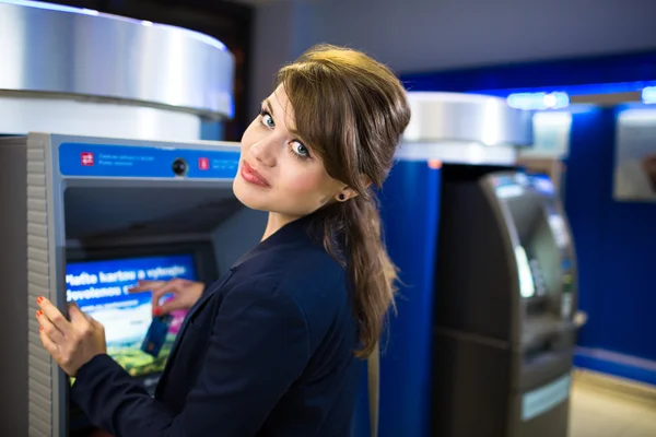 Женщина снимает деньги в банкомате — стоковое фото