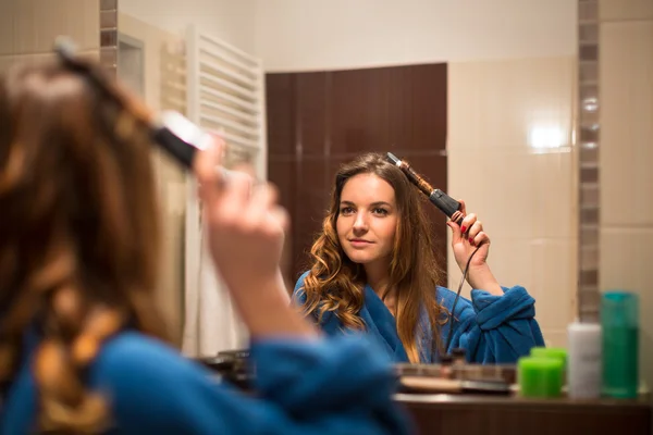 Mujer rizándose el pelo —  Fotos de Stock