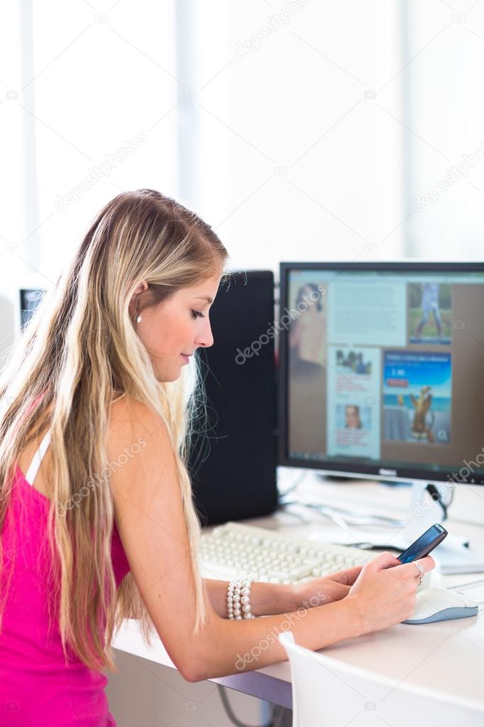 Female student with phone and laptop working