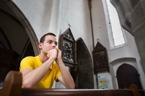 En man som ber i en kyrka — Stockfoto