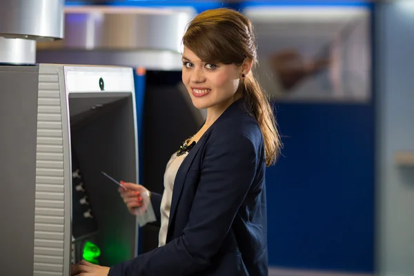 Женщина снимает деньги в банкомате — стоковое фото