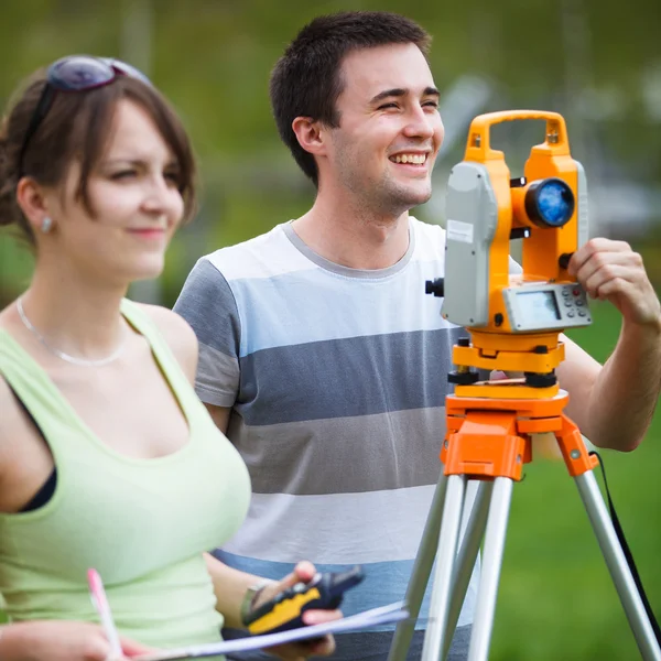 Two young land surveyors at work — Stock Photo, Image