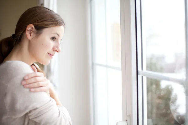 Mujer mirando desde una ventana — Foto de Stock