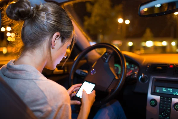 Mujer usando su teléfono inteligente en el coche — Foto de Stock