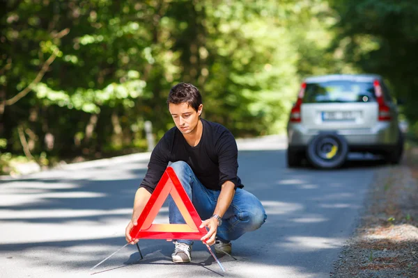 Ung man med sin bil uppdelade — Stockfoto