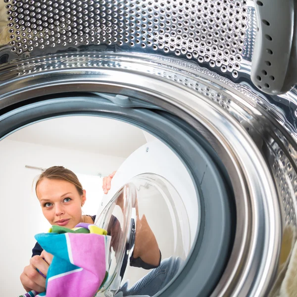 Hushållsarbete: ung kvinna gör tvätt — Stockfoto