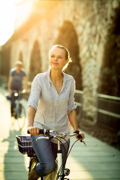 Donna in bicicletta in una città — Foto Stock